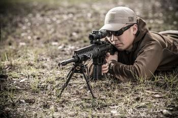 Man Aiming a Rifle with a Bipod attached
