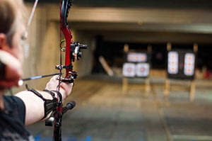 Man Shooting a Compound Bow at an Archery Range