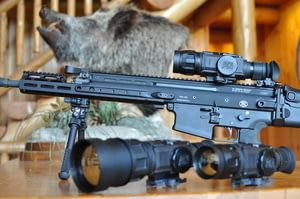 AR With ATN ThOR Rifle Scope and a Boar's Head in the Background
