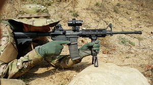 Man aiming through iron sights and red dot sight | AR15 Iron Sights Co-Witness