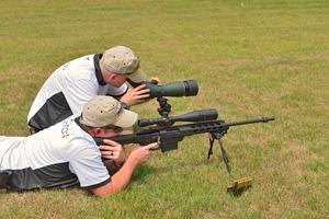 Two men with spotting scope and rifle long-range shooting