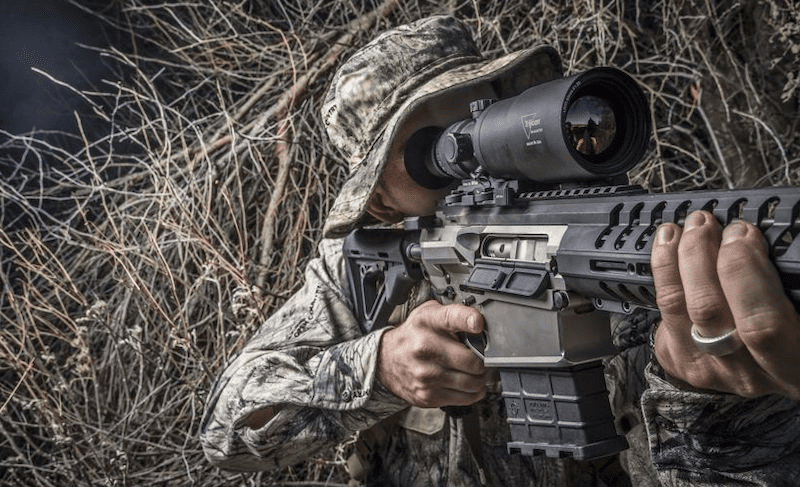 Man Shooting From Brush With a Thermal Scope on a Rifle
