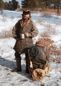 Man with an older style backpack in the wilderness